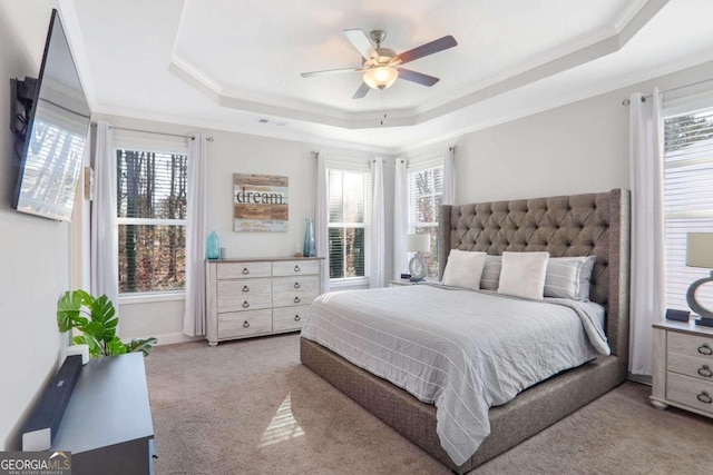 bedroom featuring light carpet, a raised ceiling, ceiling fan, and crown molding