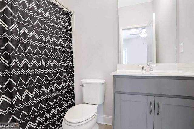 bathroom with a shower with curtain, vanity, ceiling fan, and toilet