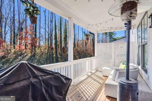 wooden terrace featuring ceiling fan and a grill