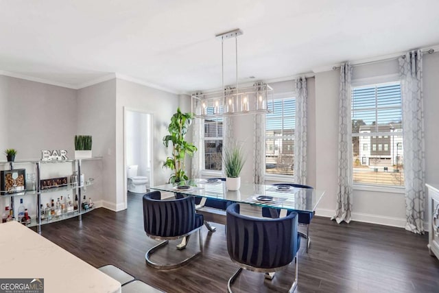 dining area with ornamental molding and dark wood-type flooring