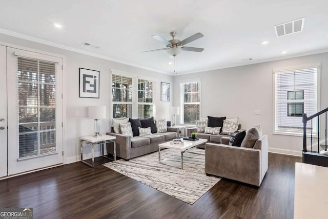 living room featuring dark wood-type flooring, a healthy amount of sunlight, and ornamental molding