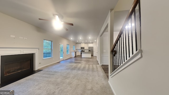 carpeted living room with ceiling fan