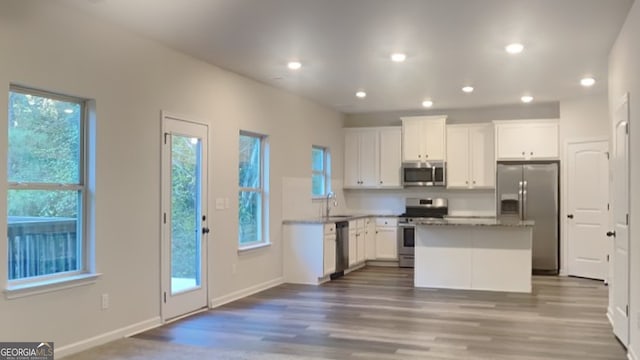 kitchen featuring a center island, white cabinets, plenty of natural light, and appliances with stainless steel finishes