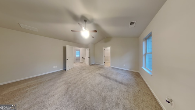 empty room featuring ceiling fan, light carpet, and vaulted ceiling