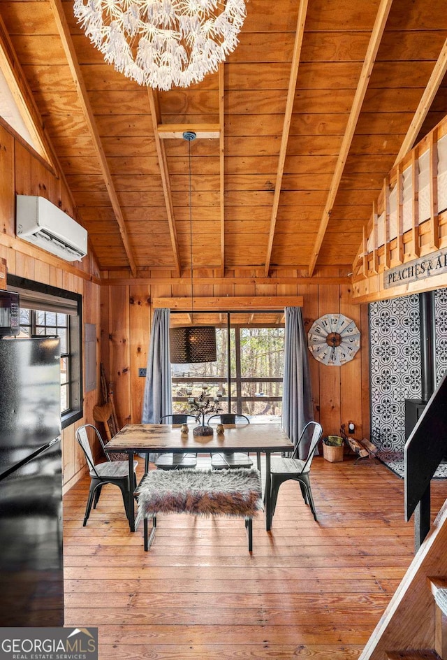 dining space with a chandelier, hardwood / wood-style floors, wooden walls, and a wall unit AC