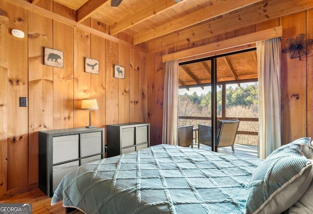 bedroom with access to exterior, wooden ceiling, beamed ceiling, hardwood / wood-style floors, and wooden walls