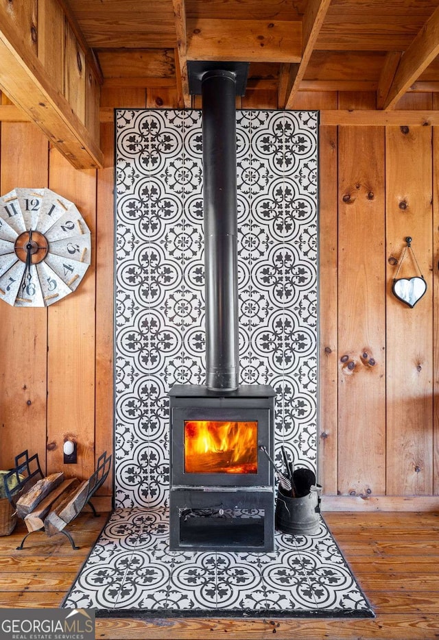 interior details with hardwood / wood-style flooring, a wood stove, and wooden walls