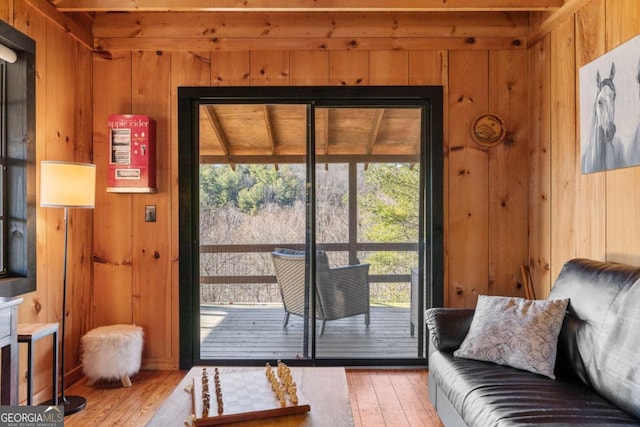 doorway to outside with hardwood / wood-style flooring and wooden walls