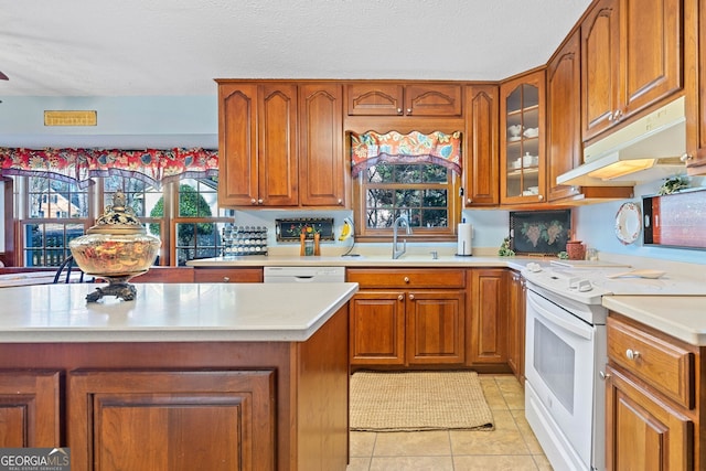 kitchen featuring sink, a textured ceiling, white appliances, and light tile patterned flooring