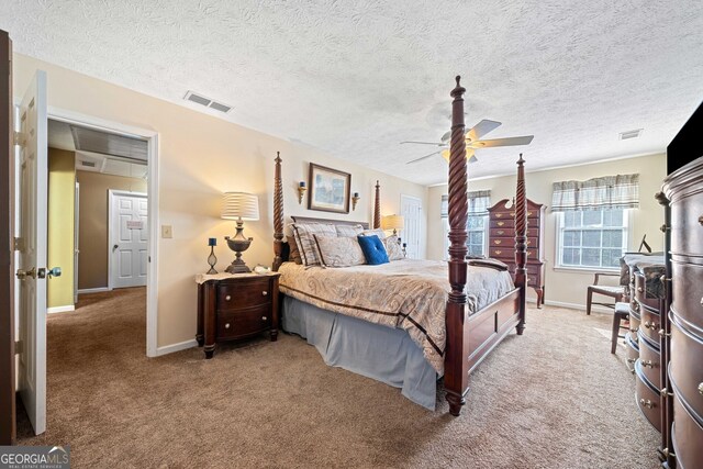 bedroom featuring ceiling fan, light colored carpet, and a textured ceiling