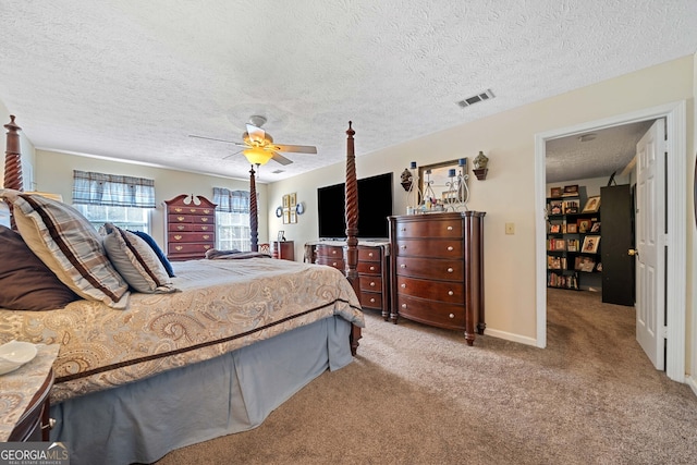 carpeted bedroom featuring ceiling fan and a textured ceiling