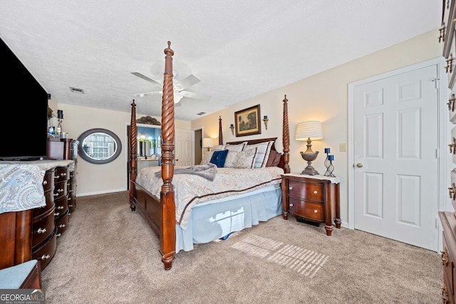 carpeted bedroom featuring a textured ceiling and ceiling fan