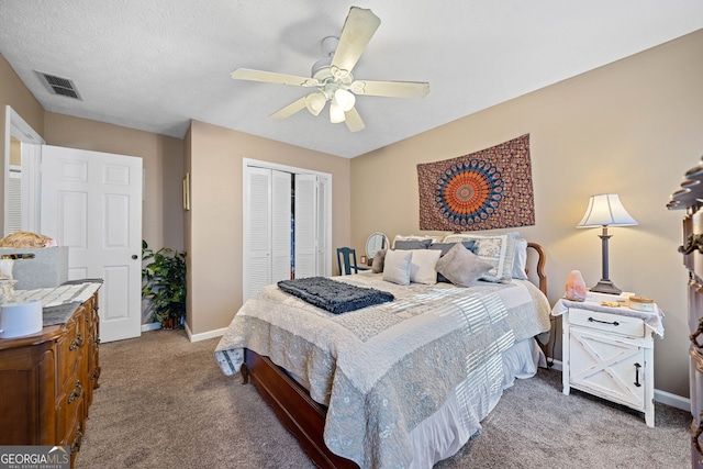 carpeted bedroom featuring ceiling fan, a closet, and a textured ceiling