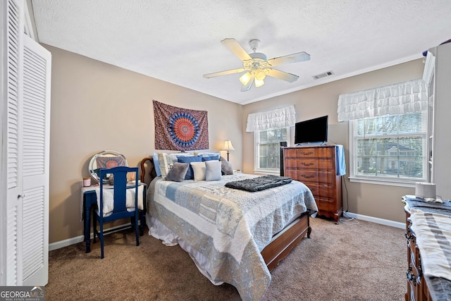 carpeted bedroom featuring a textured ceiling, a closet, and ceiling fan