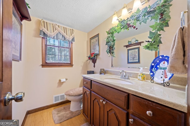 bathroom with vanity, hardwood / wood-style floors, a textured ceiling, and toilet