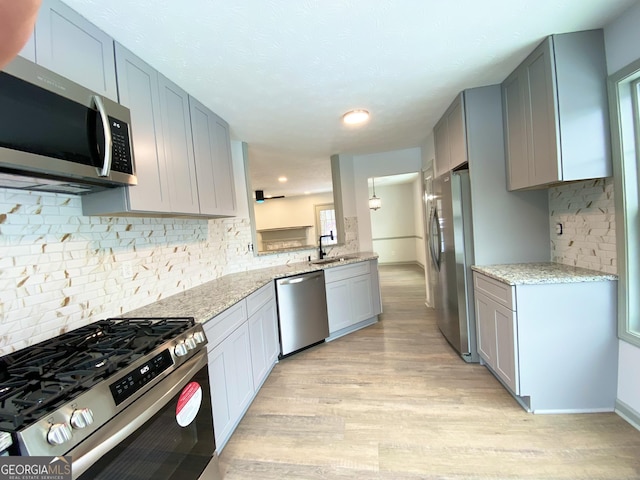 kitchen featuring gray cabinets, appliances with stainless steel finishes, sink, and light hardwood / wood-style floors