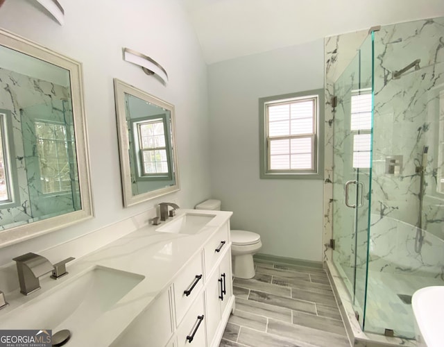 bathroom with vanity, toilet, a shower with shower door, and vaulted ceiling