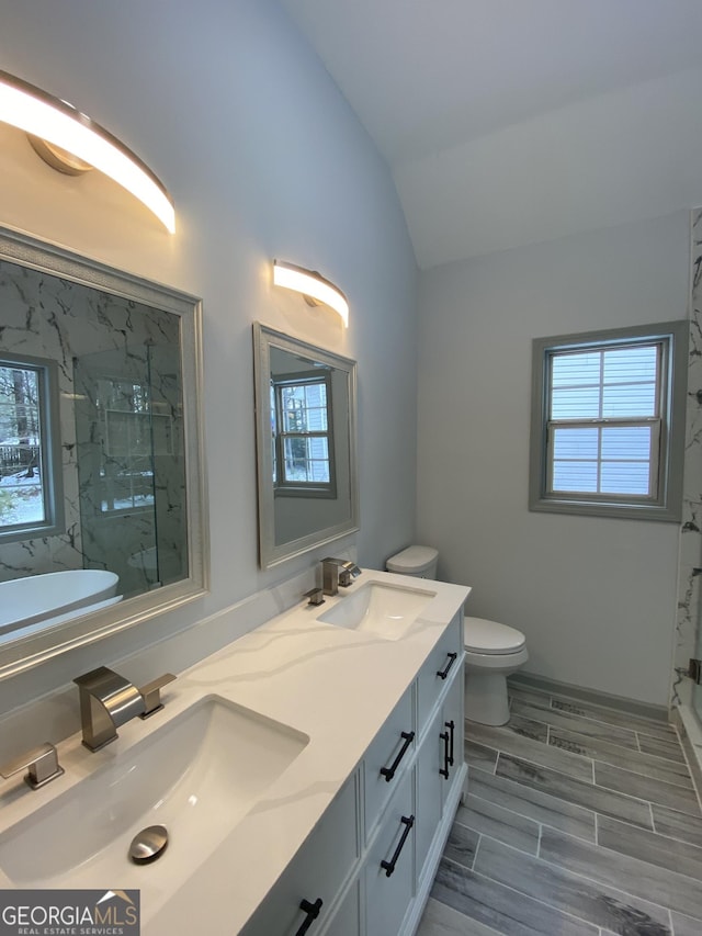 bathroom with vaulted ceiling, tiled shower, and plenty of natural light