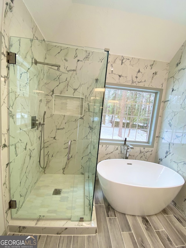 bathroom with plus walk in shower, vaulted ceiling, and tile walls