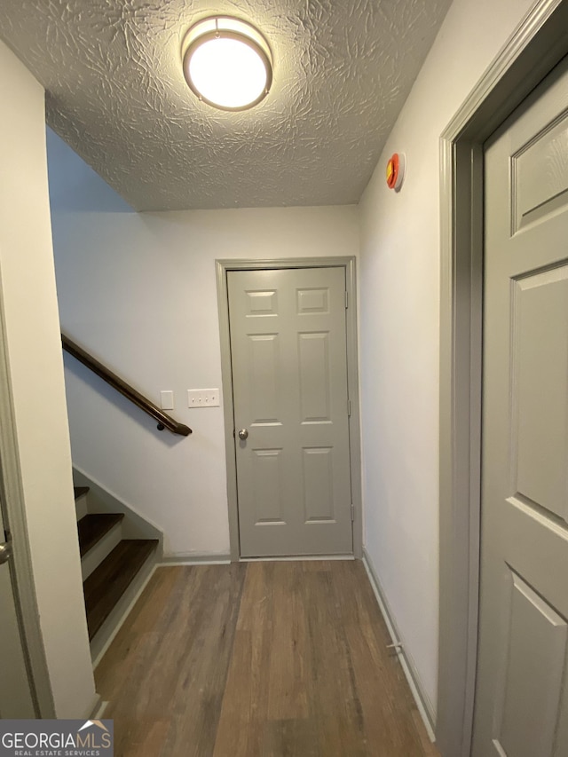 entryway featuring hardwood / wood-style flooring and a textured ceiling