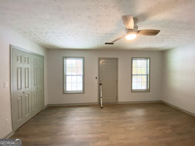 foyer with hardwood / wood-style floors, a textured ceiling, and ceiling fan