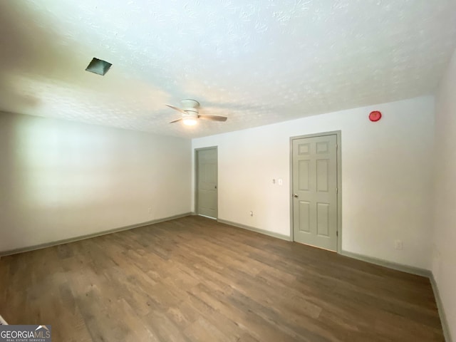 empty room with ceiling fan, hardwood / wood-style floors, and a textured ceiling