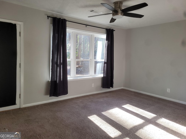 carpeted spare room featuring a wealth of natural light and ceiling fan