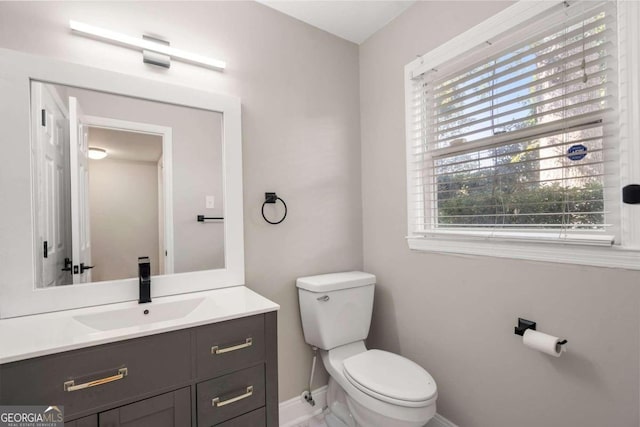 bathroom featuring vanity, a healthy amount of sunlight, and toilet