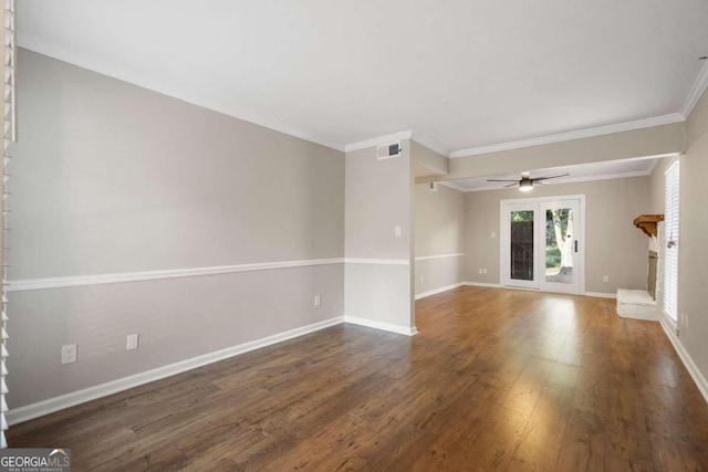 empty room featuring ornamental molding, a brick fireplace, ceiling fan, and dark wood-type flooring