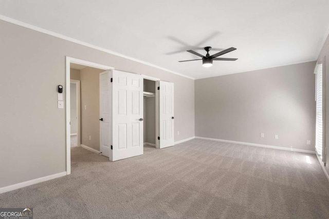 carpeted empty room with ceiling fan and ornamental molding