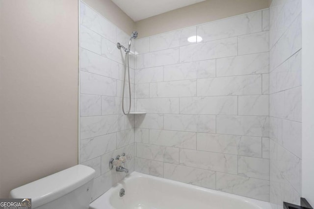 bathroom featuring toilet and tiled shower / bath