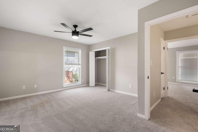 unfurnished bedroom featuring a closet, light colored carpet, and ceiling fan