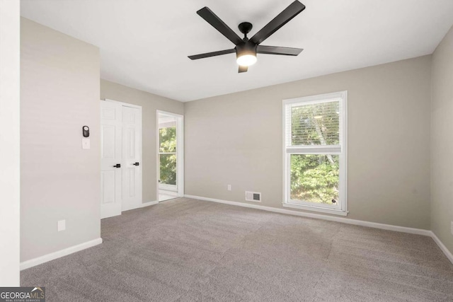 carpeted spare room with ceiling fan