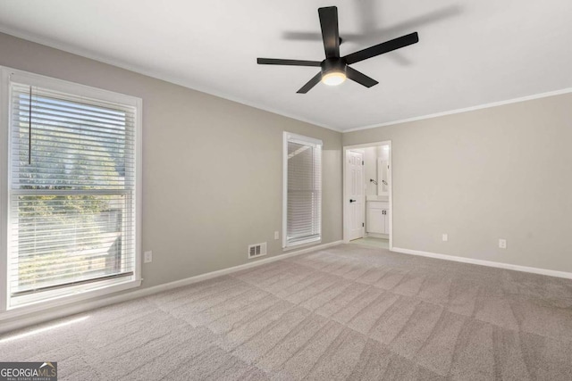 carpeted spare room featuring ceiling fan and crown molding