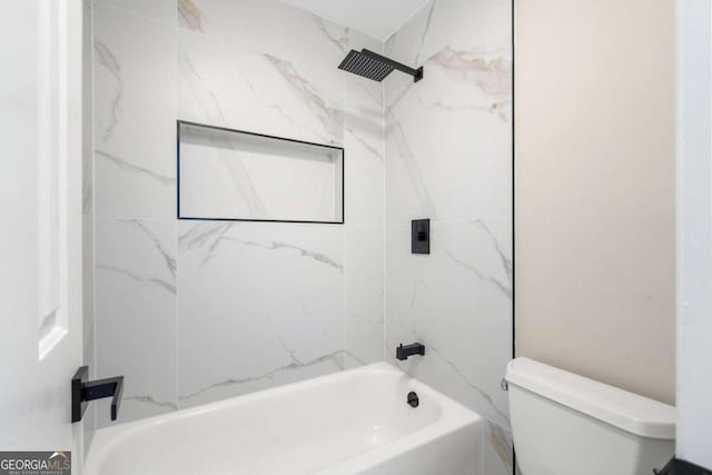 bathroom featuring tiled shower / bath and toilet