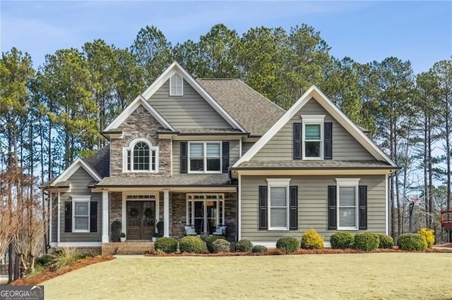 craftsman-style home featuring covered porch and a front lawn