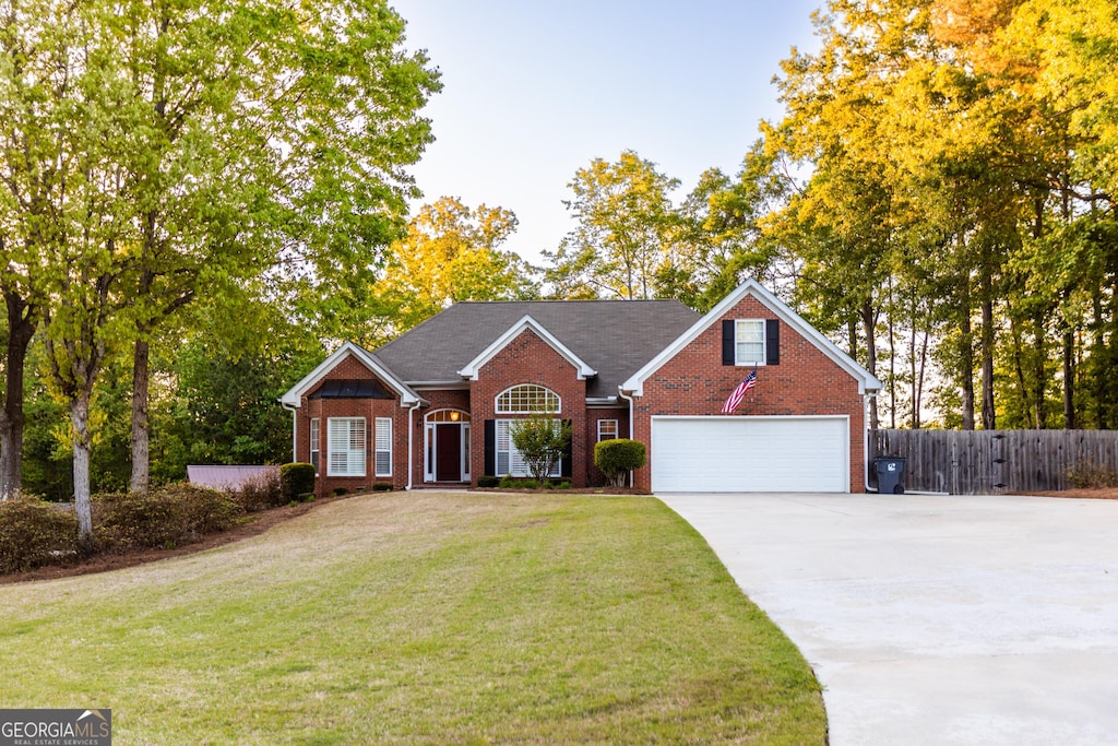 single story home featuring a front lawn and a garage