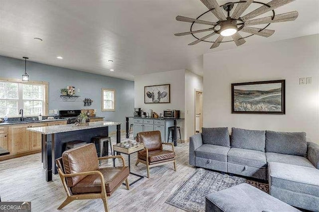 living room featuring light hardwood / wood-style flooring, a healthy amount of sunlight, and sink