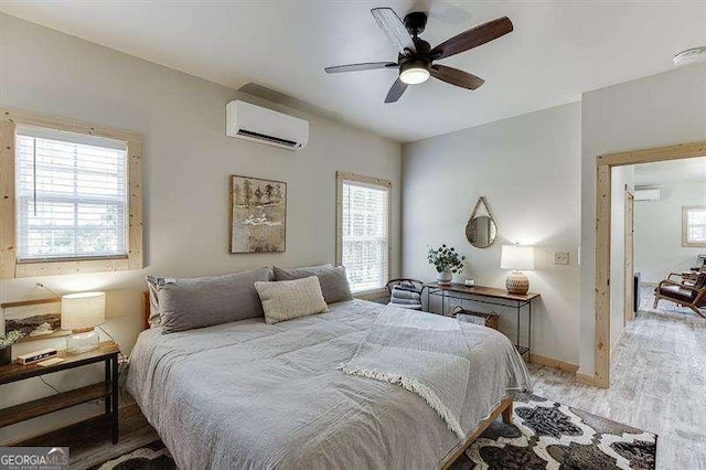 bedroom featuring ceiling fan, light hardwood / wood-style floors, multiple windows, and a wall mounted AC