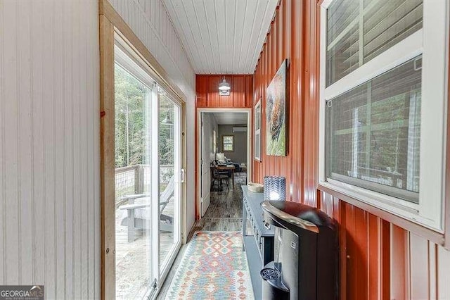 doorway with wood walls and wooden ceiling