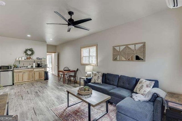 living room featuring ceiling fan and light hardwood / wood-style floors