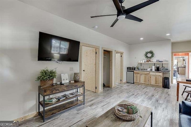 living room featuring light wood-type flooring and ceiling fan