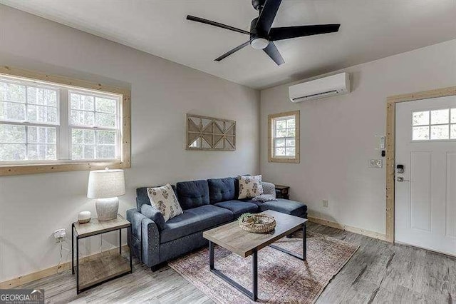 living room featuring an AC wall unit, ceiling fan, and wood-type flooring