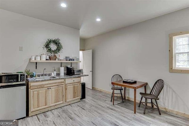 kitchen with refrigerator, light hardwood / wood-style floors, and sink