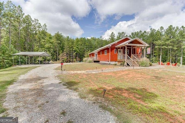 view of front of home with a front yard, a porch, and a carport