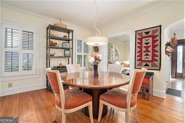 dining area featuring plenty of natural light, hardwood / wood-style floors, and crown molding