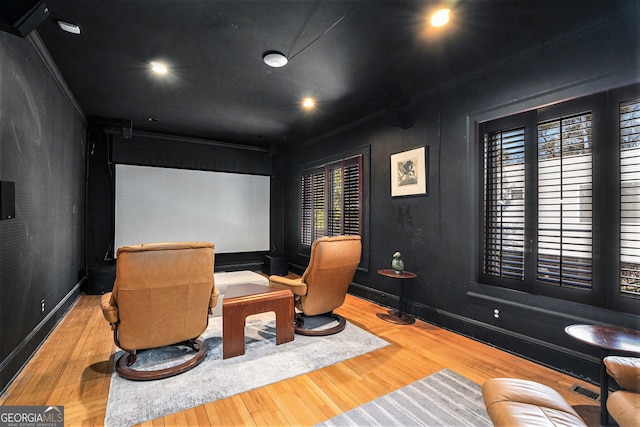 cinema with hardwood / wood-style flooring and crown molding