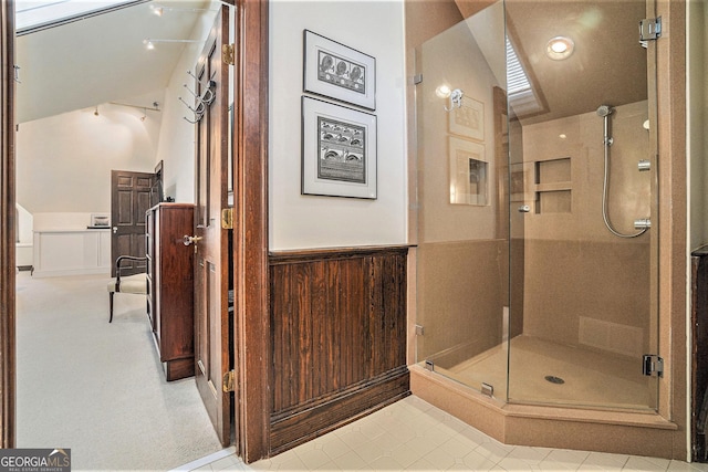 bathroom featuring a shower with shower door and wooden walls