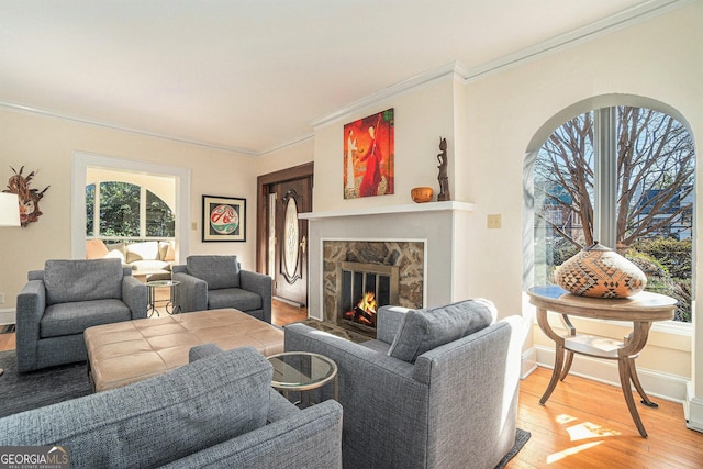 living room with a high end fireplace, ornamental molding, and hardwood / wood-style flooring