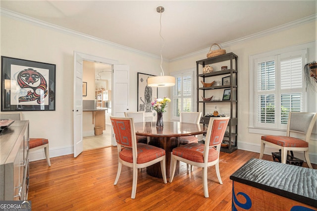 dining room featuring light hardwood / wood-style flooring and ornamental molding